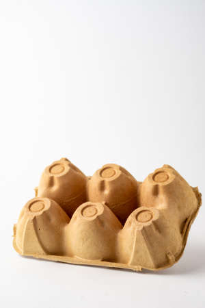 Top view of empty brown carton for six eggs, for recycling, white background, vertical, with copy...