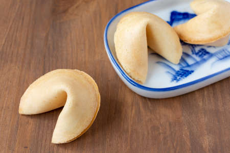 Top view of fortune cookies on chinese plate, on wooden table, horizontal, with copy spaceの写真素材