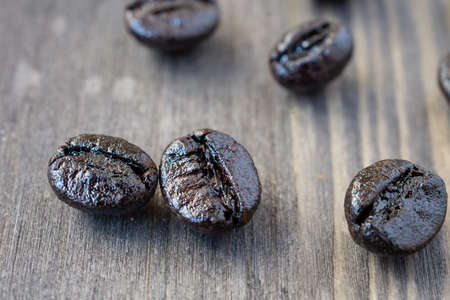 Close-up of roasted coffee beans, on dark wooden table, selective focus, horizontalの写真素材