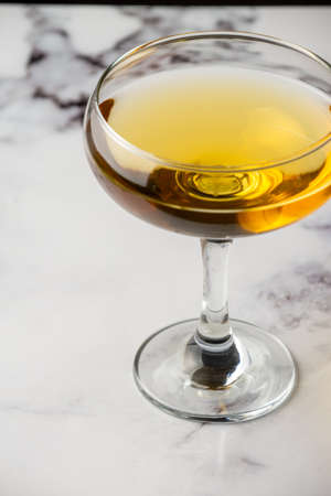 Aerial view of cocktail glass on white marble table, selective focus, vertical, with copy spaceの写真素材