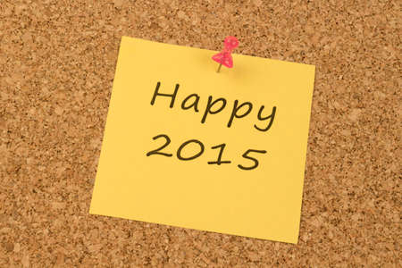 Yellow sticky note on an office cork board. Happy 2015の写真素材