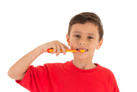Young boy feeling happy and brushing his teeth, wearing red t-shirt , isolated on white background