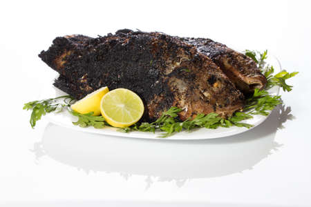 homemade dish of grilled tilapia fish with lemon and parsley