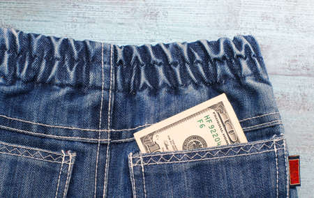 Money in a jeans back pocket on blue wooden backgroundの写真素材