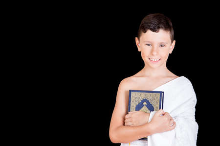 Cute Muslim Kid Praying While Wearing Ihram ( White Traditional Islamic Clothes ) During Hajjの写真素材