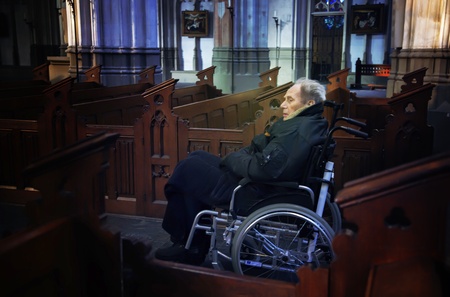 Old man in wheel chair inside  churchの写真素材