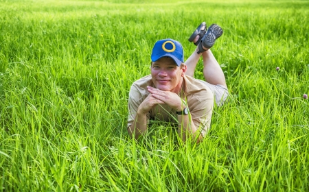 man in grass by summer seasonの写真素材