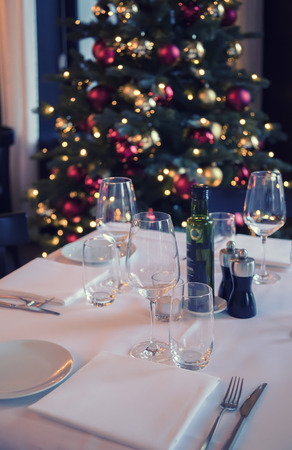 restaurant table and christmas tree as backgroundの写真素材