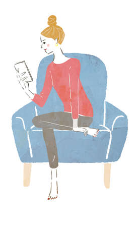 A woman touching her cellphone on the sofaの写真素材