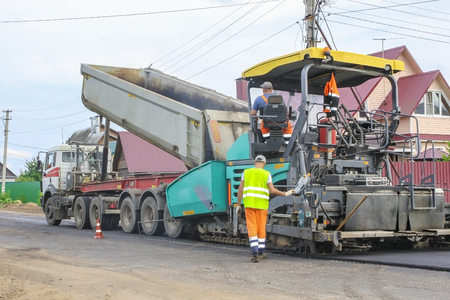 Work on laying of an asphalt paving by means of heavy machineryのeditorial素材