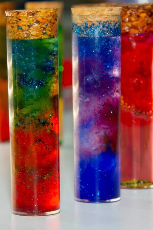 Test tubes with multi-colored liquid inside closed by traffic jams