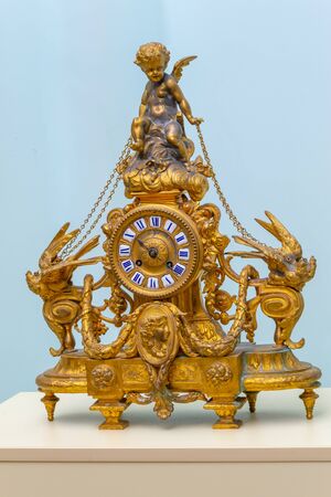 Old gilded fireplace clock with an angel and birdsの写真素材