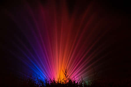 Fountain at night with multi-colored lighting on a black backgroundの写真素材