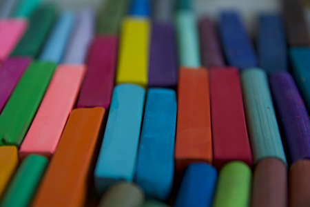 Blurred photo with chopsticks of multicolored art pastels suitable for the background. Symbol of creativity, joy, rich choice.の写真素材