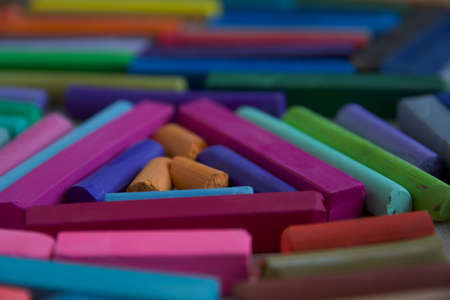 Blurred photo with chopsticks of multicolored art pastels suitable for the background. Symbol of creativity, joy, rich choice.の写真素材