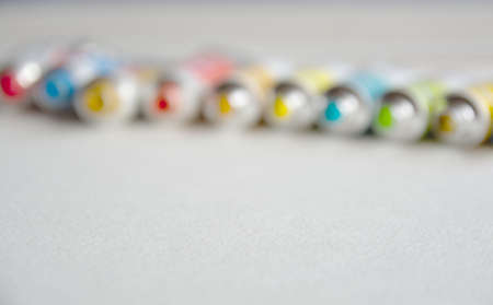 Blurred photo of tubes close-up with bright multi-colored watercolors blue, yellow, green shades. Good background for art publications.の写真素材