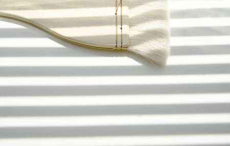 Watercolor brushes on a sheet of watercolor paper in the shadows of the blinds.の写真素材