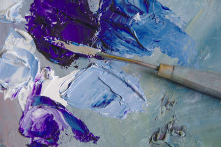 Artist's palette with blue oil paints with a palette knife.の写真素材