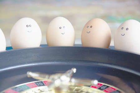 Group of happy eggs (friends ) make bets gambling at the toy roulette in the toy casino.の写真素材