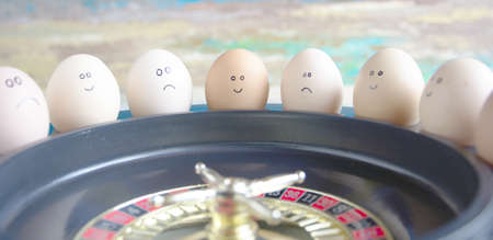 Group of happy and sad eggs (friends ) make bets gambling at the toy roulette in the toy casino.