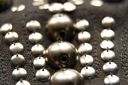Silver shiny beads and sequins in vintage style are sewn on black coarse fabric.の写真素材