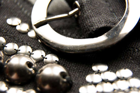 Silver shiny beads and sequins in vintage style are sewn on black coarse fabric. In the frame, a...