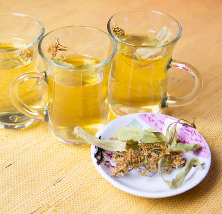 Herbal linden tea, anti-inflammatory tea in glass glasses. Dry linden blossom on a saucer.の写真素材