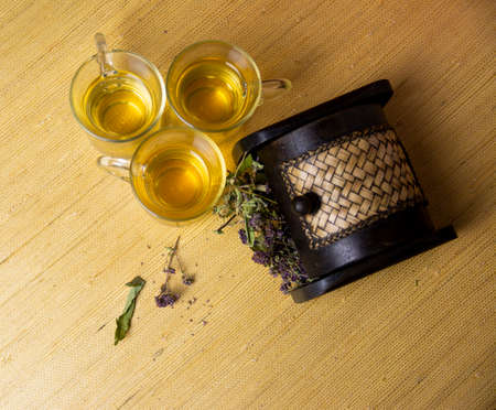 Herbal tea from a mixture of anti-inflammatory medicinal herbs in glass glasses. Herbs in a wooden box.の写真素材