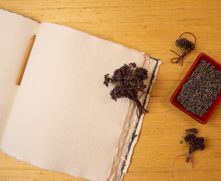 Handmade cotton notebook or sketchbook. Can be used as mocap. Nearby is a cup of herbal tea and dried flowers.の写真素材