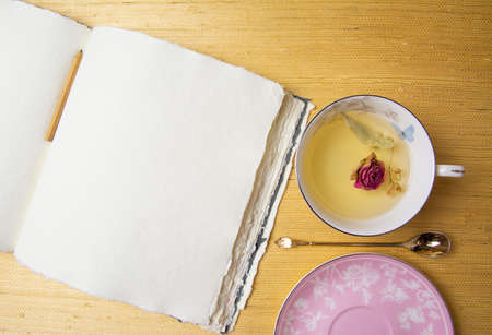 Handmade cotton notebook or sketchbook. Can be used as mocap. Nearby is a cup of herbal tea and dried flowers.の写真素材