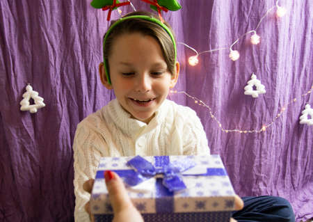 A 10-year-old European boy receives and enjoys a Christmas present.の写真素材