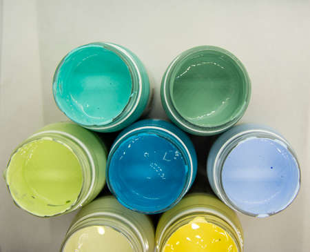 Jars of acrylic paint in green, blue, yellow shades close-up.の写真素材