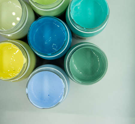 Jars of acrylic paint in green, blue, yellow shades close-up.の写真素材