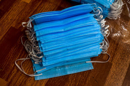 A bunch of masks which are blue in color on the floor .の写真素材