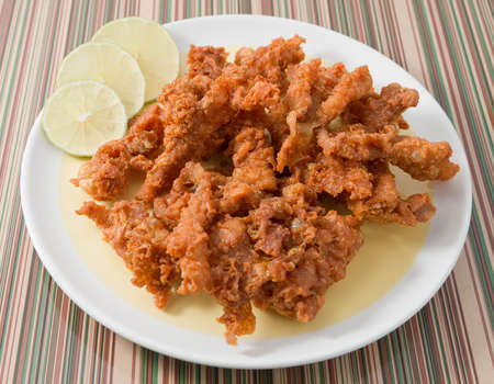 Snack and Dessert, Thai Traditional Snacks Crispy Fried Chicken Skins Served with Green Lime on A Plate.の写真素材