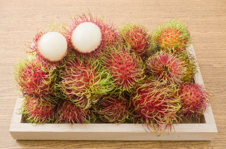 Fresh Fruits, Delicious Ripe and Sweet Refreshing Rambutan Served on Wooden Tray.