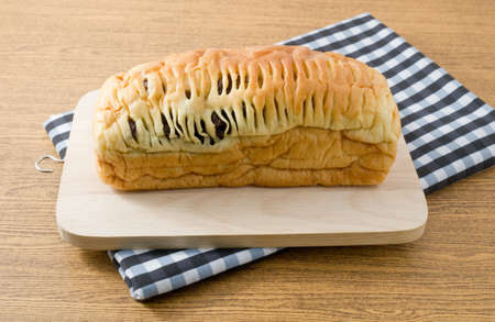 Cuisine and Food, Homemade Loaf of Brown Raisin Bread on Wooden Cutting Board.