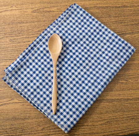 Utensil Wooden Spoon on A Blue and White Checked Towel Background.の写真素材