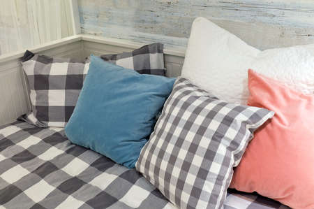 White Wooden Cozy Sofa with Five Decorative Throw Pillows, Close Up.
