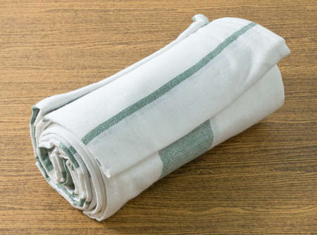Kitchen Utensil, White and Green Napkin, Serviette or Kitchen Towel on Wooden Table with Copy Space...