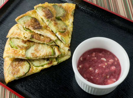 Thai Cuisine and Food, Thai Green Eggplant Omelet Served with Spicy Shrimp Paste Dip on A Black Tray.の写真素材