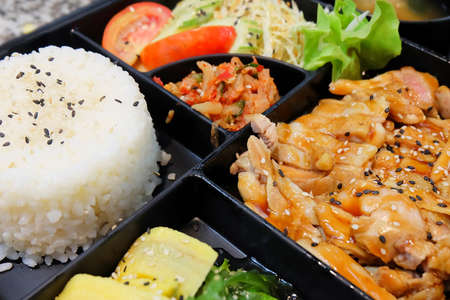 Traditional Japan Cuisine, Bento Box or Multi-Layered Box with Teriyaki Chicken Rice, Salad, Tamagoyaki or Rolled Omelette, Hiyashi Wakame or Seaweed Salad and Kimchi.の写真素材