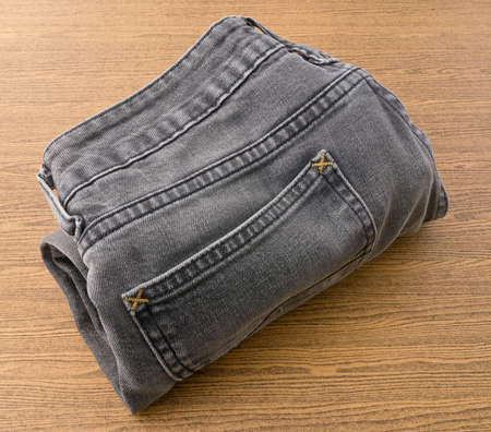 Fabric Texture, Close Up of Black Denim Jean on Wooden Background.の写真素材