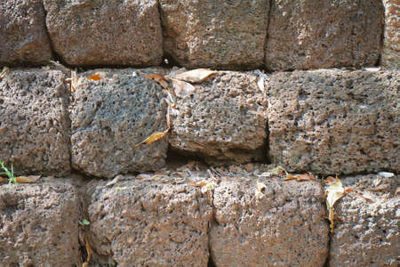 Background Textured of Red Laterite Brick Stones Wall. Laterite Is A Soil and Rock Type Used As Building Stone in The Construction of Monument Building and Historic Site.の写真素材