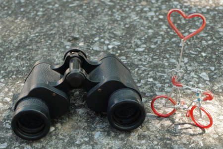 Love Concept, Classic Metallic Black Binoculars or Field Glasses and Bicycle Figure with Red Heart.