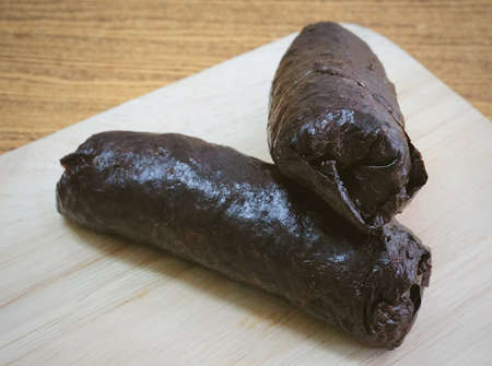 Japanese Cuisine, Traditional Unsliced Japanese Rice Maki Sushi Roll with Nori Seaweed on Cutting Board.の写真素材