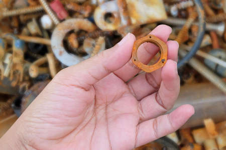 Hand Holding A Metallic Hex Nut or Locknut Used in Conjunction with Screw and Bolt Fastener to Hold Item in Place Securely.の写真素材