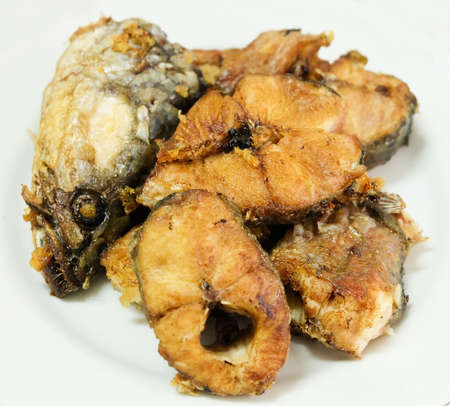 Traditional Delicuous Deep Fried Striped Snakehead Fish on A White Plate, High in Protein, Vitamin B12, Niacin or B3 and Omega-3, Essential Nutrient for Life.の写真素材