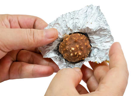 Sweet Food, Hand Opening Round Chocolate Candy Ball or Chocolate Bonbon From The Golden Wrapper...