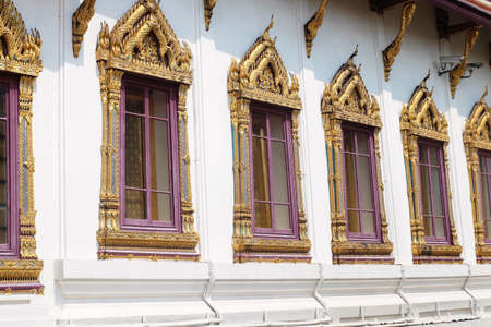 The Chapel with Beautiful Golden Windows and Base-Relief Sculpture of Naga at Wat Phra Kaew Temple and The Grand Palace. Bangkok, Thailand.の写真素材